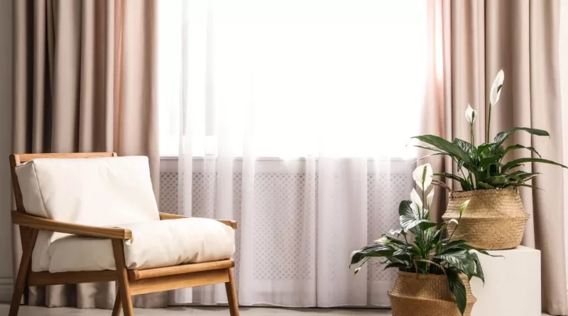 image in a blog how to select curtains, featuring beige curtains and wooden accent chair