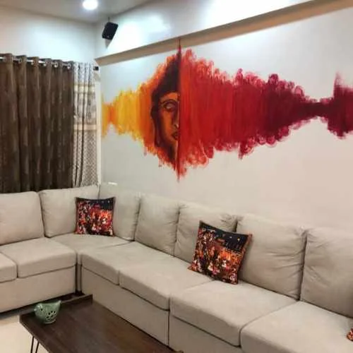 A small wall area painted with a Buddha face and vibrant color splashes to Make Your Dull Home Look Vibrant
