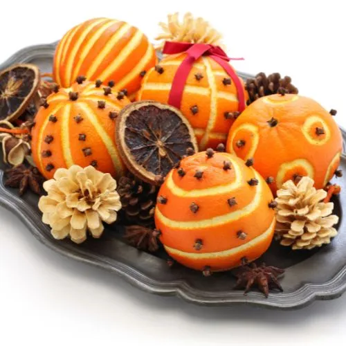 Image of oranges adorned with cloves for Christmas decor. The combination adds a touch of tradition and a delightful fragrance. 