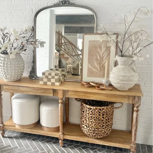 A rustic, multifunctional entryway table decor with shelves to keep decorative artifacts and ottoman.