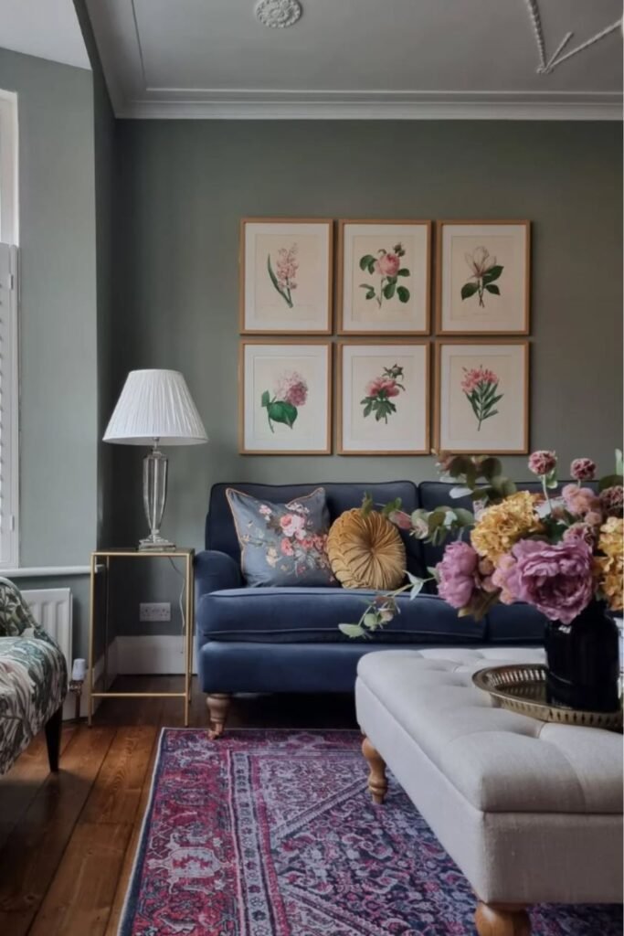 Navy blue sofa with floral artwork on muted green wall