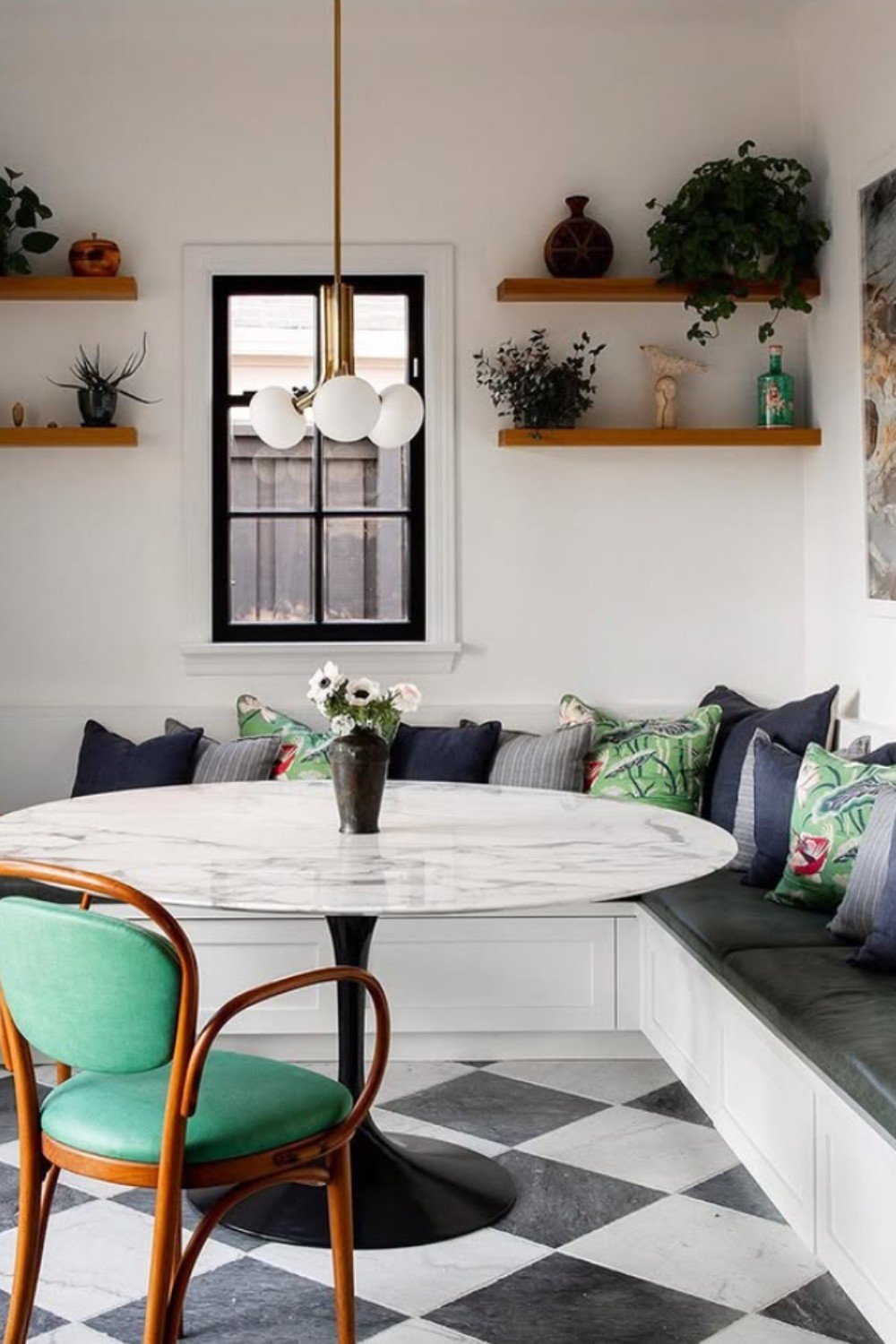 Small dining nook with marble round table and light black and white checkered floor.