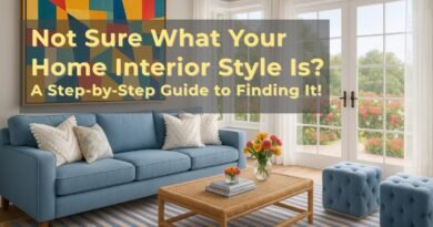 Bright and modern living room with a blue sofa, abstract wall art, woven coffee table, colorful pillows, and large windows opening to a blooming garden view. Overlay text reads "Not Sure What Your Home Interior Style Is? A Step-by-Step Guide to Finding It!
