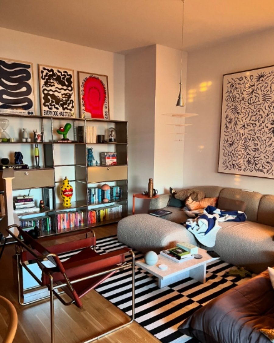 black and white striped rug, art gallery walls, and curved modern sofa in a living room