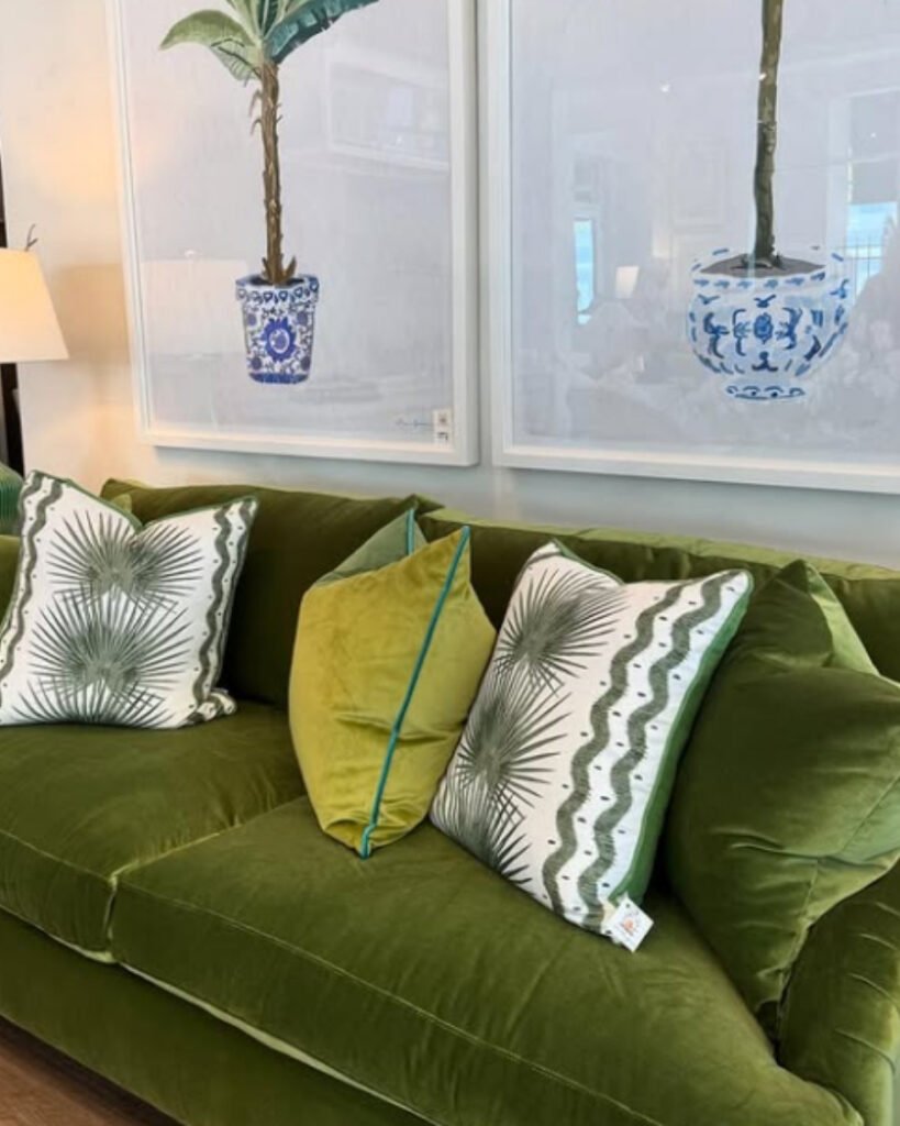 Olive green, a unique sofa color with patterned cushions near a sunlit window and planters