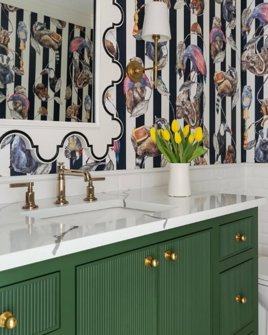 vibrant bathroom with animal wallpaper, black‑and‑white stripes, green vanity, brass fixtures
