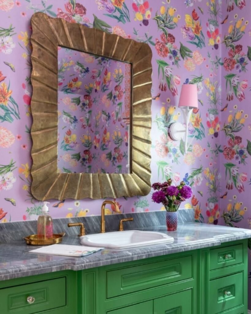 floral wallpaper bathroom with green vanity, gold accents, pink sconce