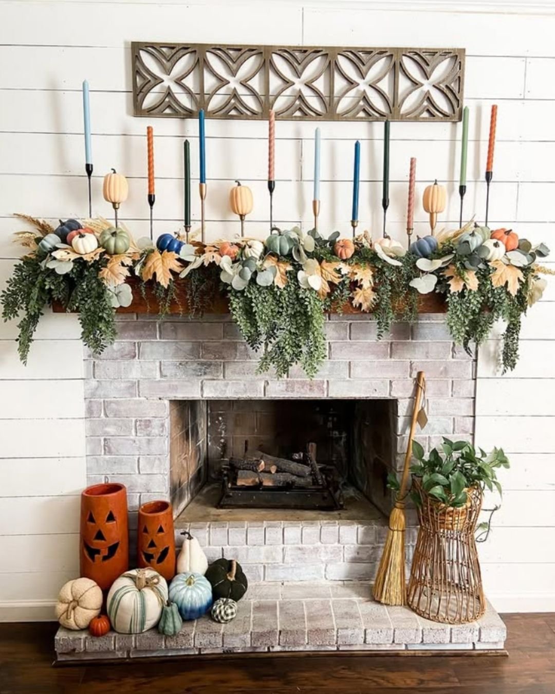 Fall mantel decorating ideas with colorful taper candles, greenery garlands, and soft pastel pumpkins.