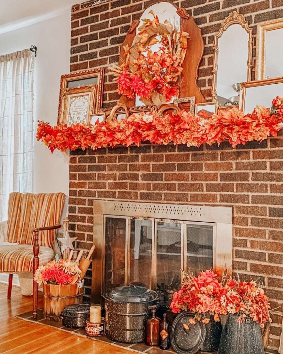 Fall mantel decorating ideas with dark brick, vintage frames, and warm autumn florals.