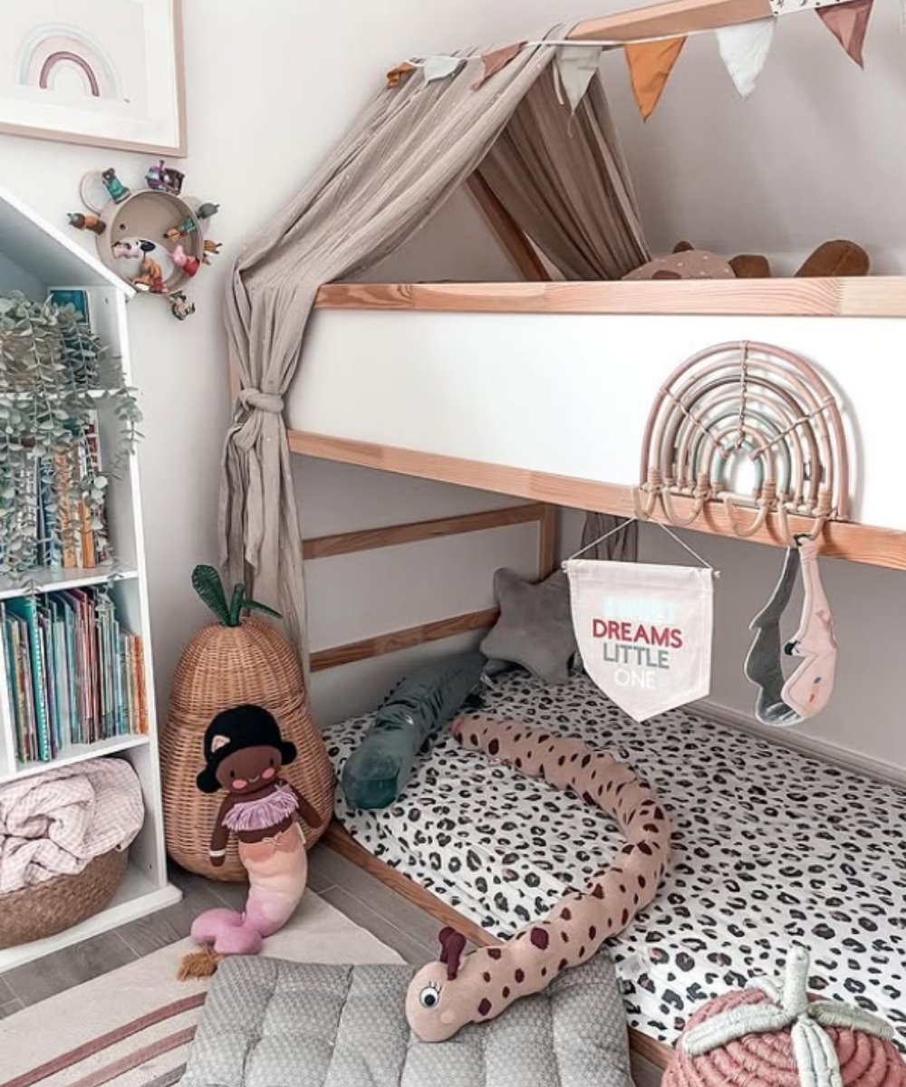 Montessori bunk bed with soft toys, canopy, and bookshelf