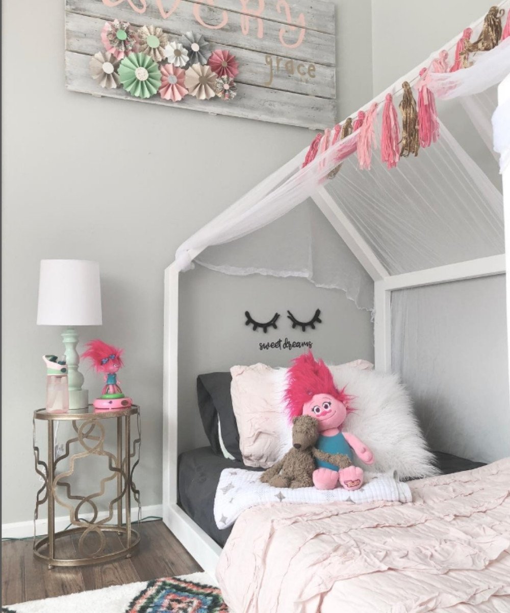 Montessori white house-frame bed with tassel decor and soft pink bedding
