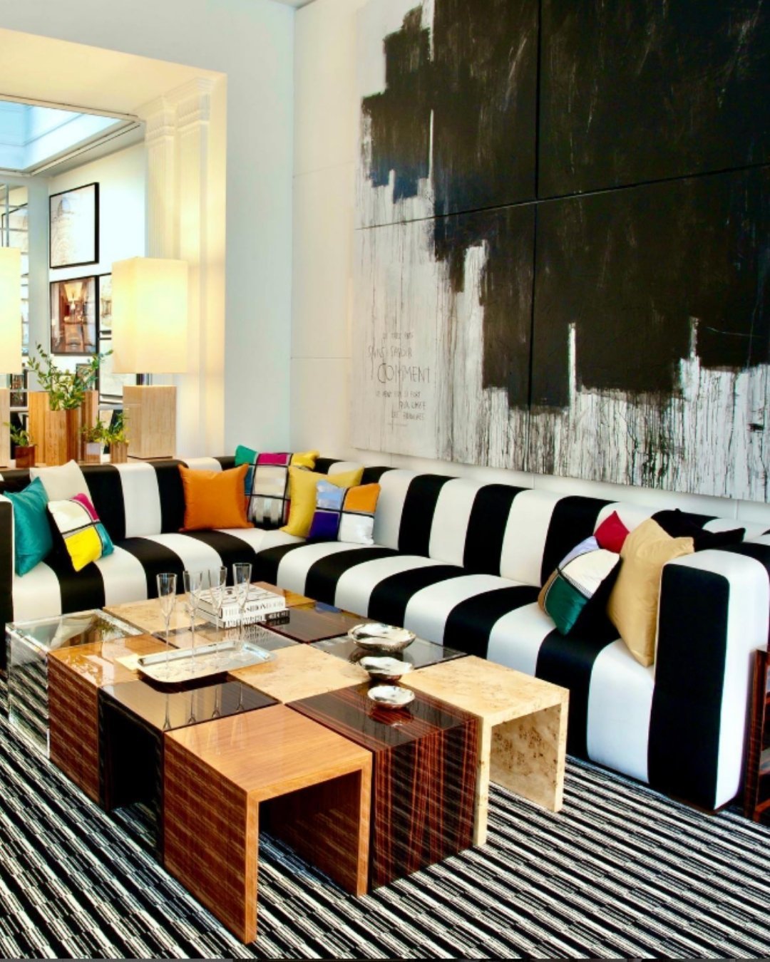 Black and white striped sectional with colorful throw pillows in a modern living room