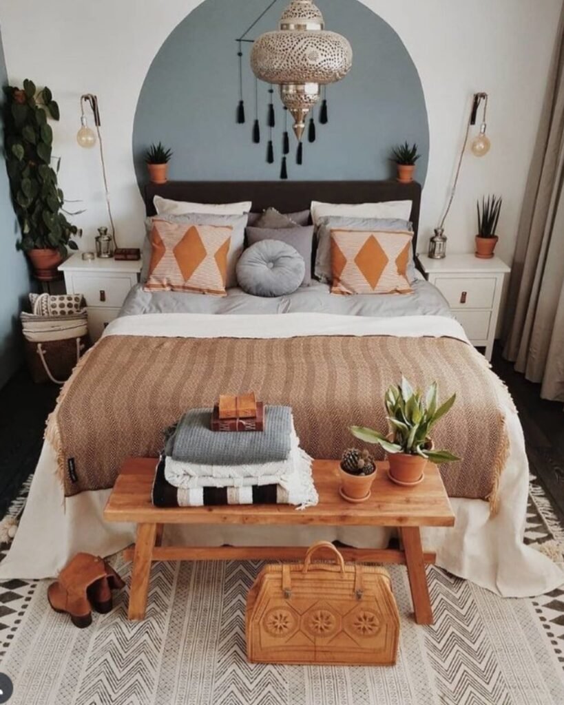 Earthy Moroccan boho bedroom with clay tones, brass lighting, and layered textiles