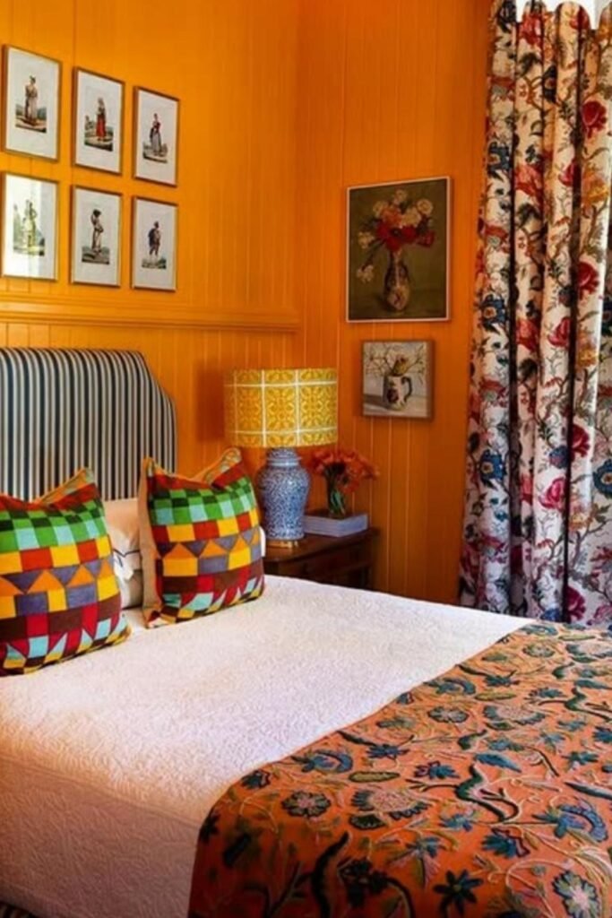 Retro-style orange room with multicolored cushions, patterned curtains, and playful accessories—bold orange color bedroom ideas with personality.