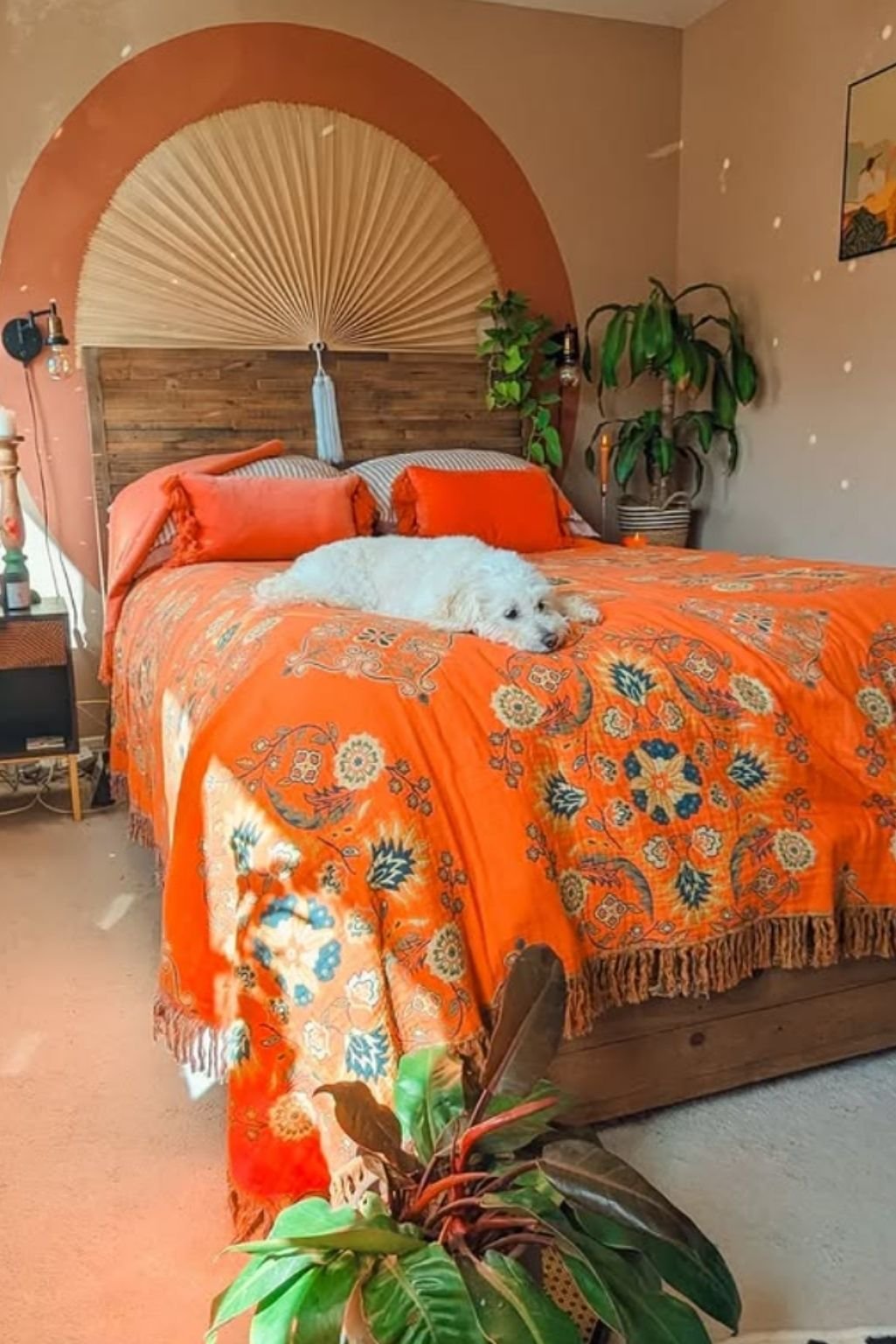 Bright orange bedding with floral prints and natural accents, set in a warm-toned rustic bedroom.