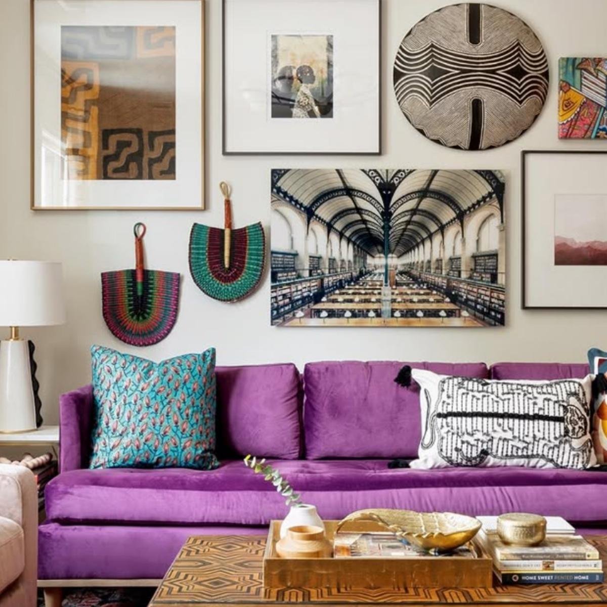 Boho-style room featuring a bright purple sofa with tribal wall decor and colorful cushions.