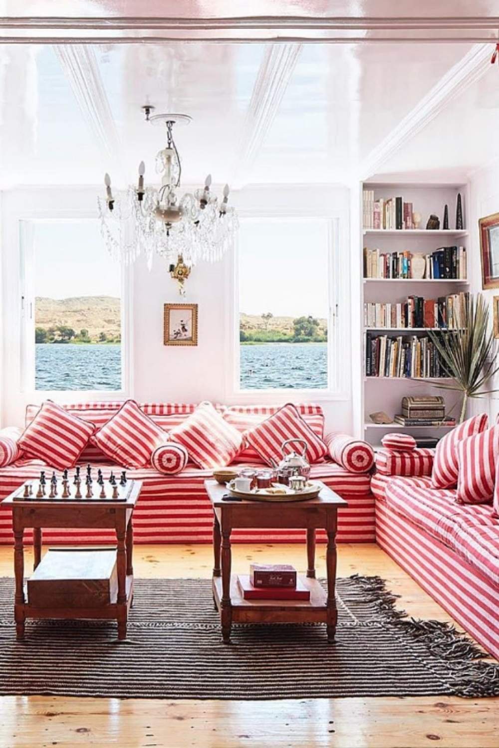 Red and white striped sofas in a cozy lake-view library room