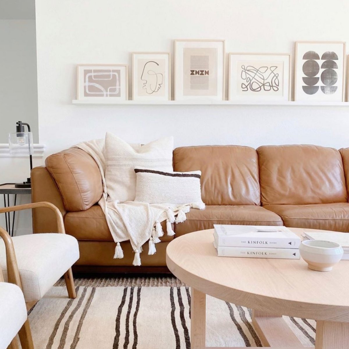 Soft beige-toned living room with tan sofa, striped rug, and white walls