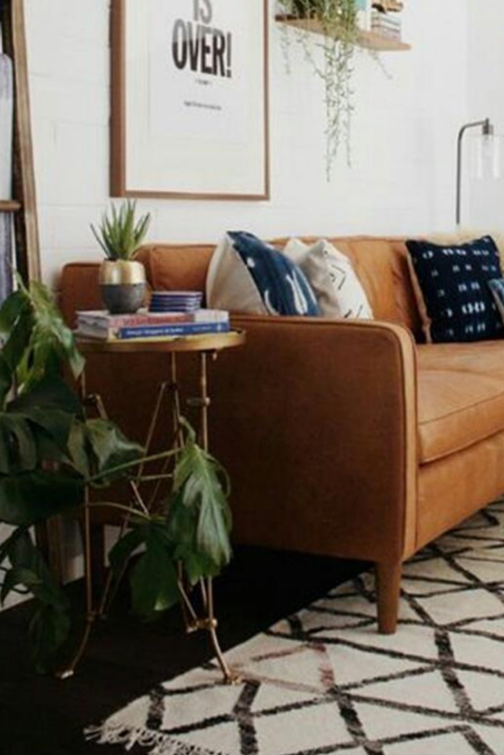  Boho-style tan sofa with patterned rug and overflowing greenery