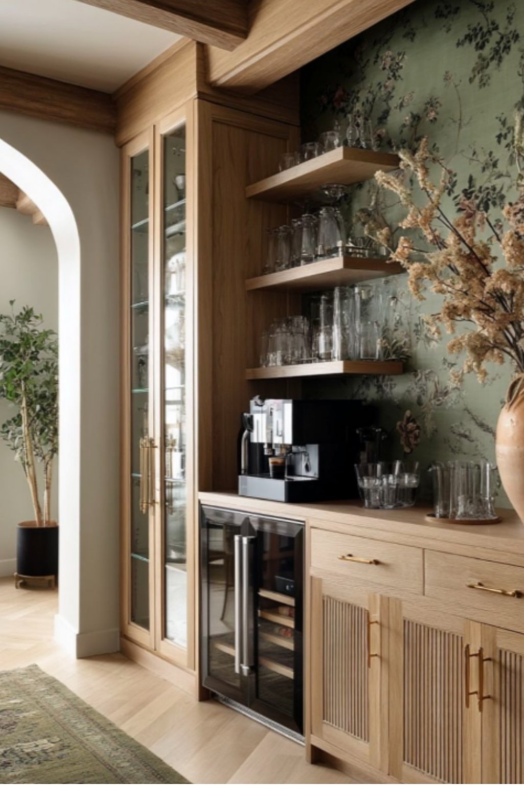 Rustic kitchen corner featuring white oak kitchen cabinets with reeded doors, open shelves, and antique gold hardware set against a floral wallpaper backdrop.