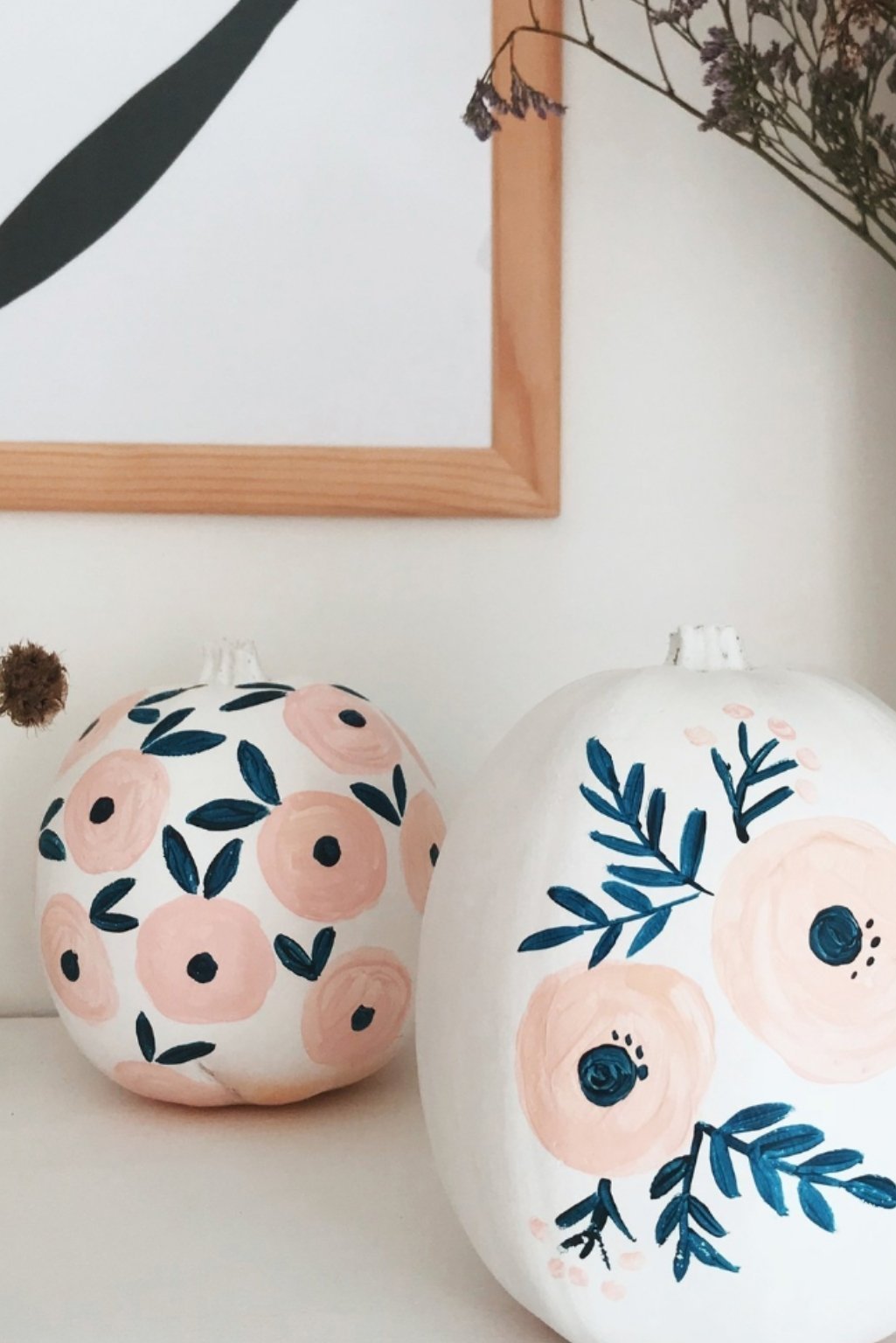 Hand-painted white pumpkins with floral and leaf patterns in pastel tones.