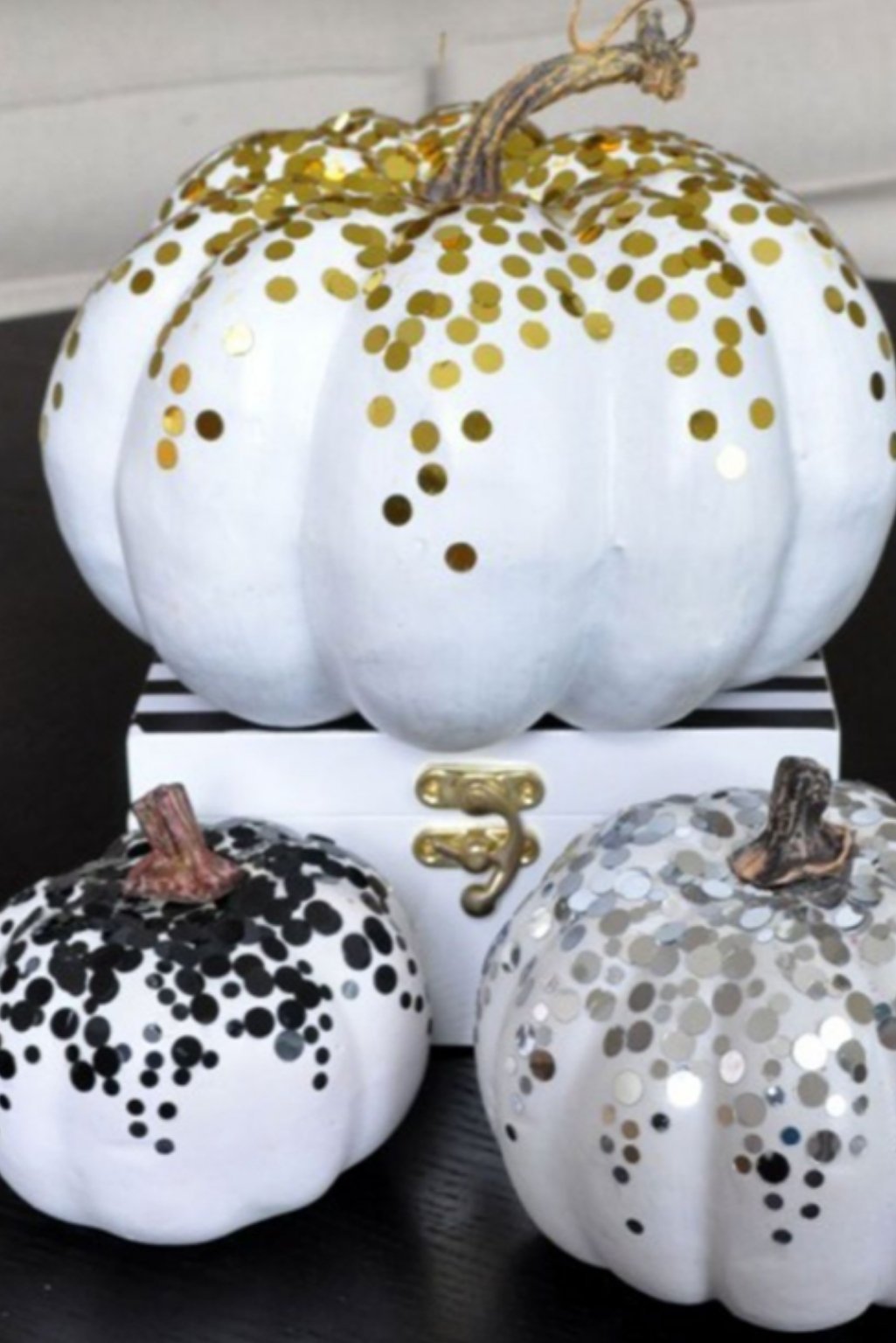 White pumpkins decorated with black and gold sequins for a festive glam look.