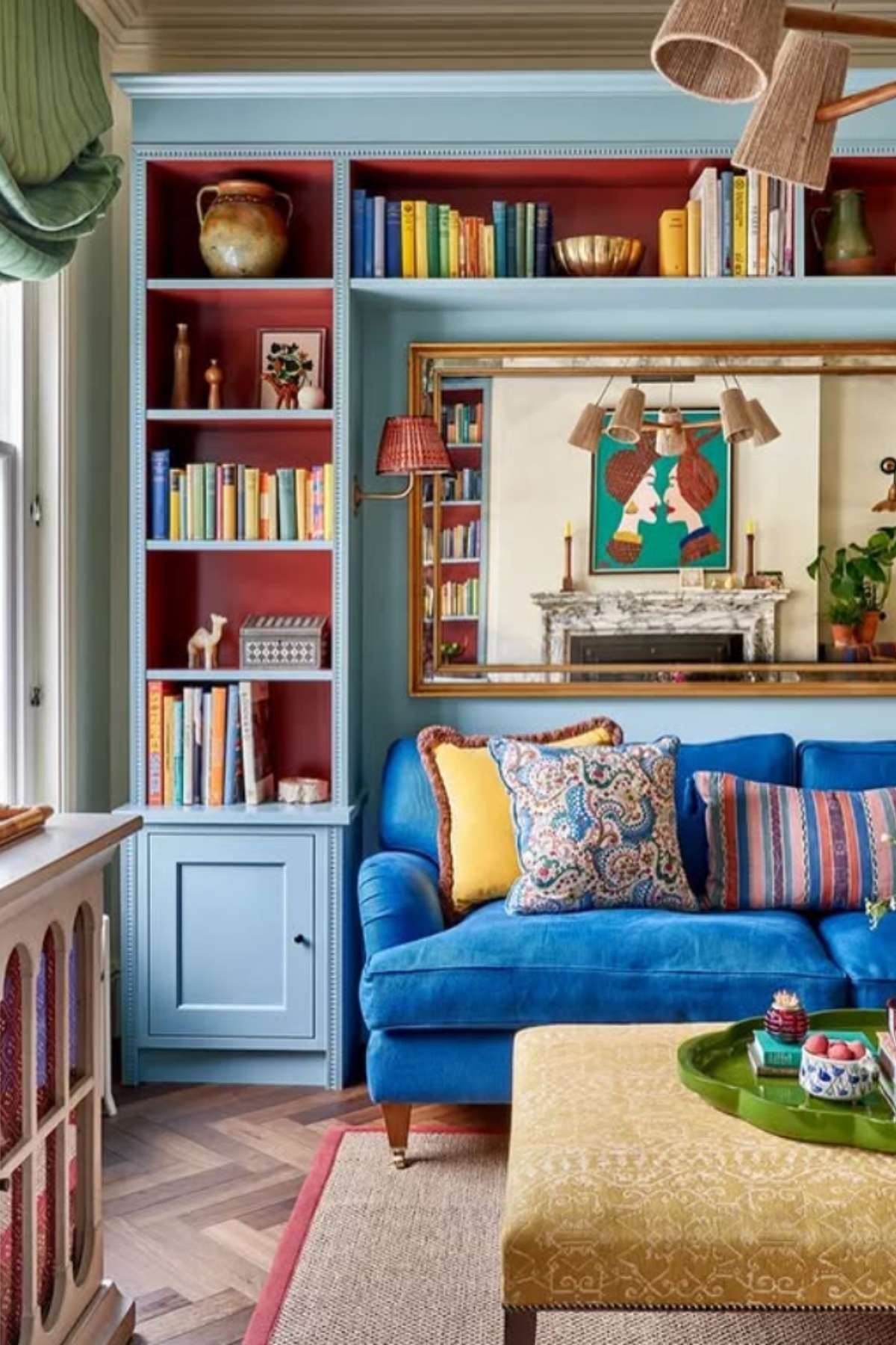 Deep blue sofa in front of light blue built-ins with mustard cushions.