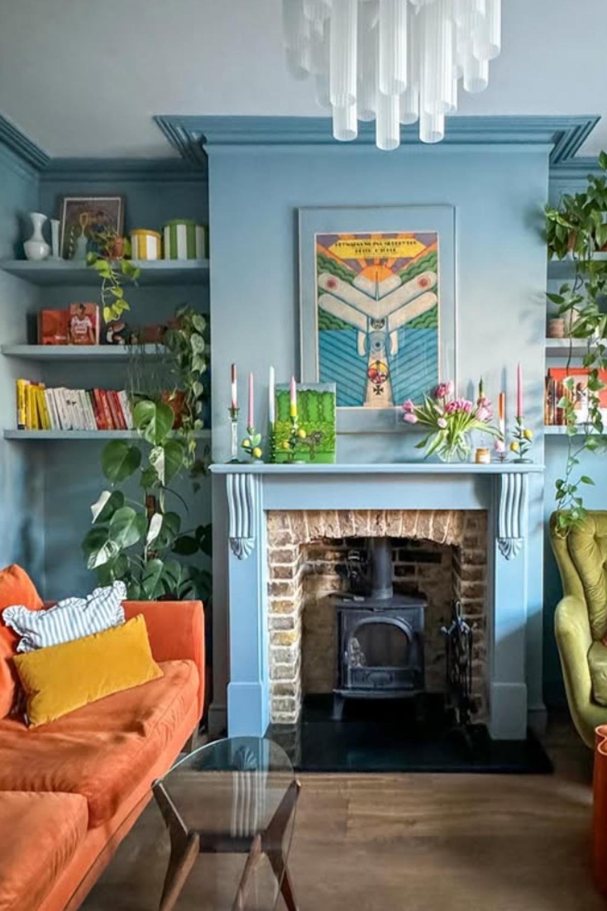 Burnt orange sofa with mustard pillows against blue walls.