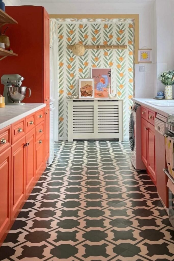 Coral cabinets with patterned black-and-white flooring.