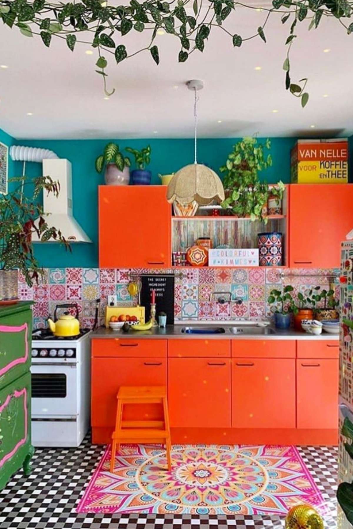 Bright orange cabinets with patterned backsplash and colorful rug.