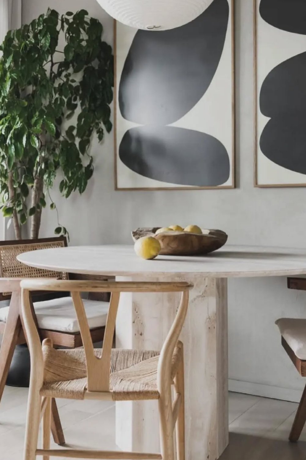 wood table, sculpted chairs, and abstract wall art.