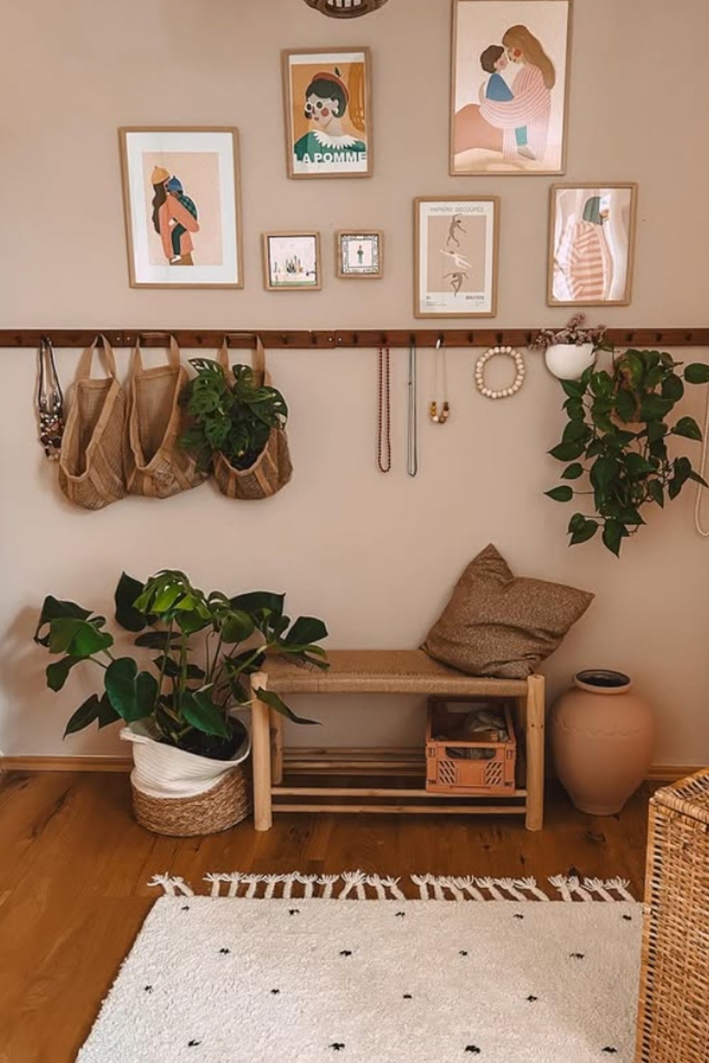 Boho nook wall with framed art, plants, and small bench seating.