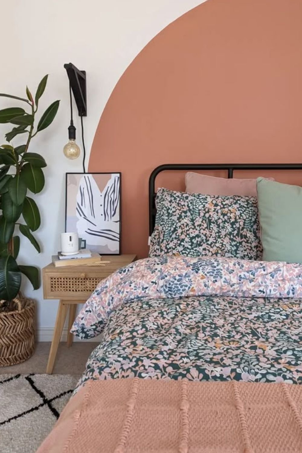 Painted terracotta arch behind bed with boho plants and minimalist artwork.