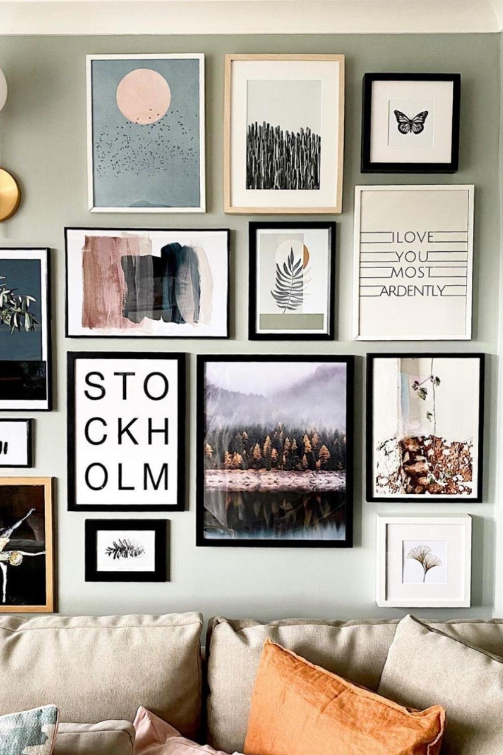 Eclectic gallery wall with typography, photography, and abstract prints on a muted background.