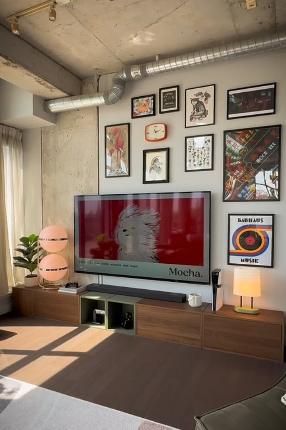 Modern gallery wall framing a TV with geometric, typographic, and photographic art.