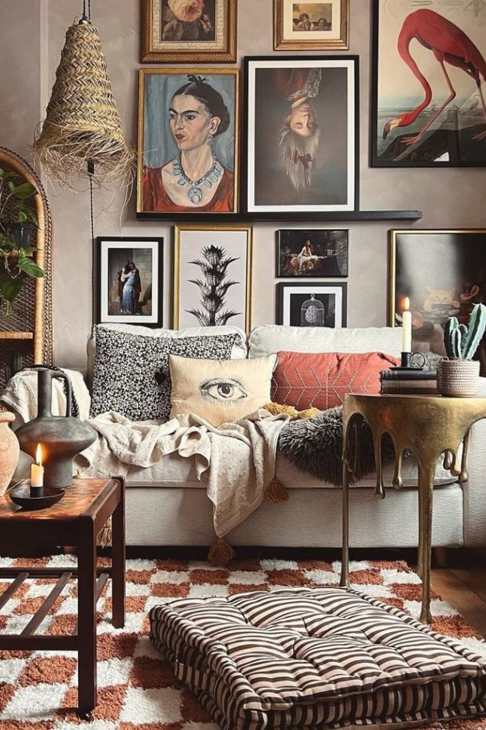 Soulful gallery wall with portraits, including a Frida piece, above earthy-toned furniture.