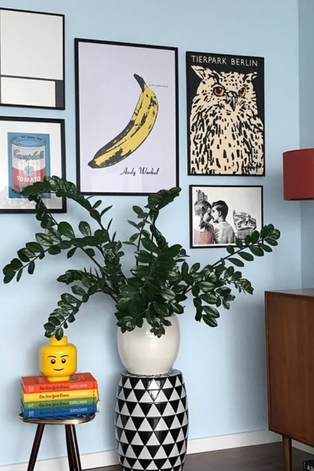 Playful eclectic gallery wall with iconic banana print, greenery, and bold monochrome vase.