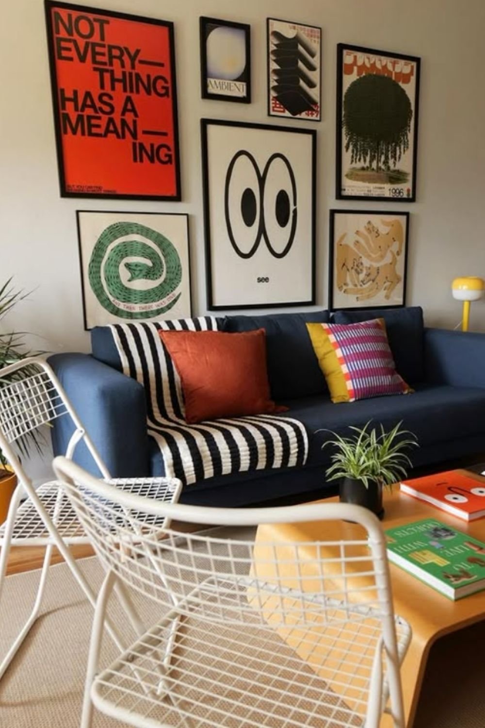 Eclectic gallery wall with oversized eyes, typography, and abstract designs above a cozy couch.