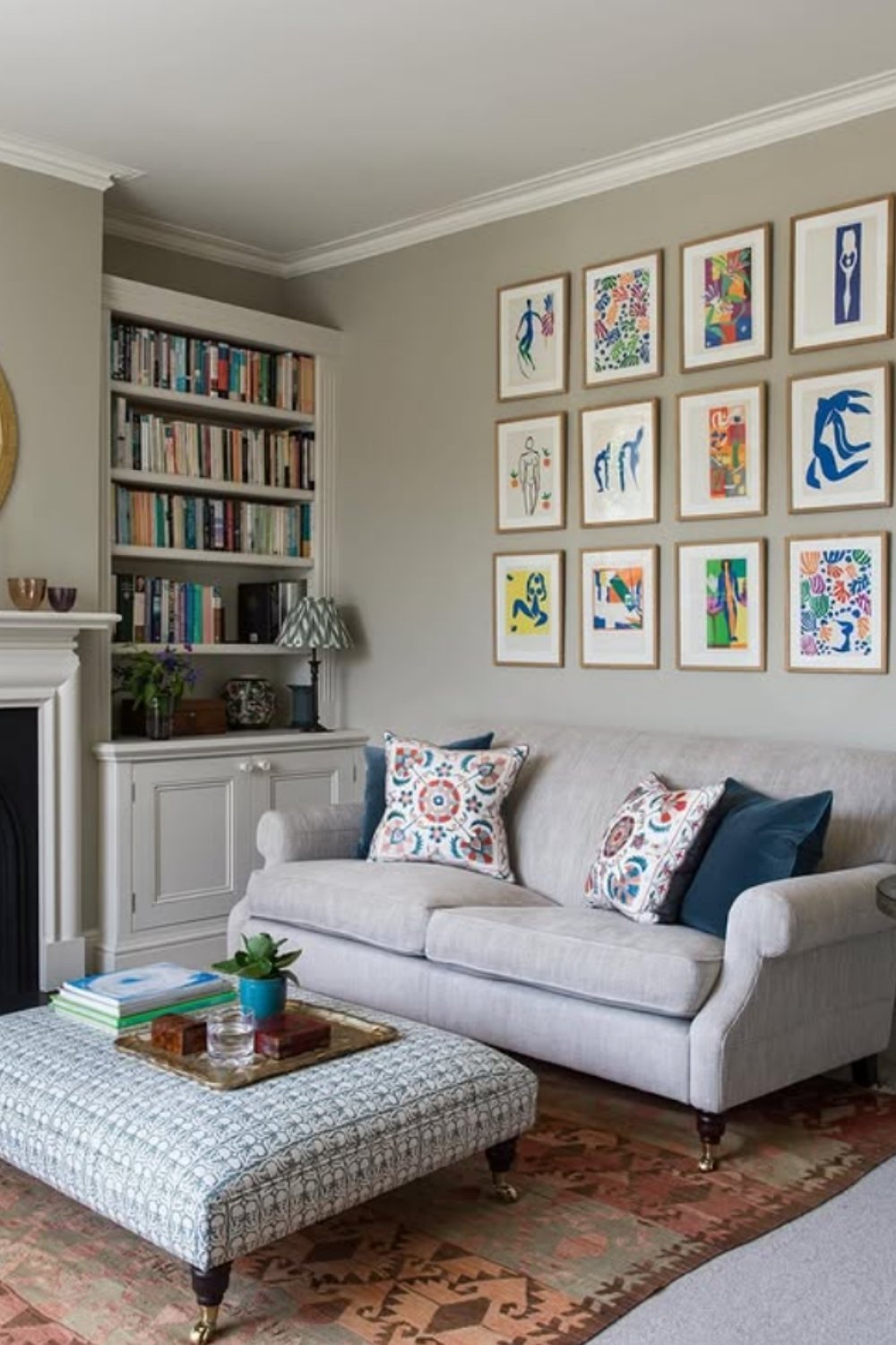 Cozy eclectic gallery wall in a neutral-toned living room with colorful framed prints.