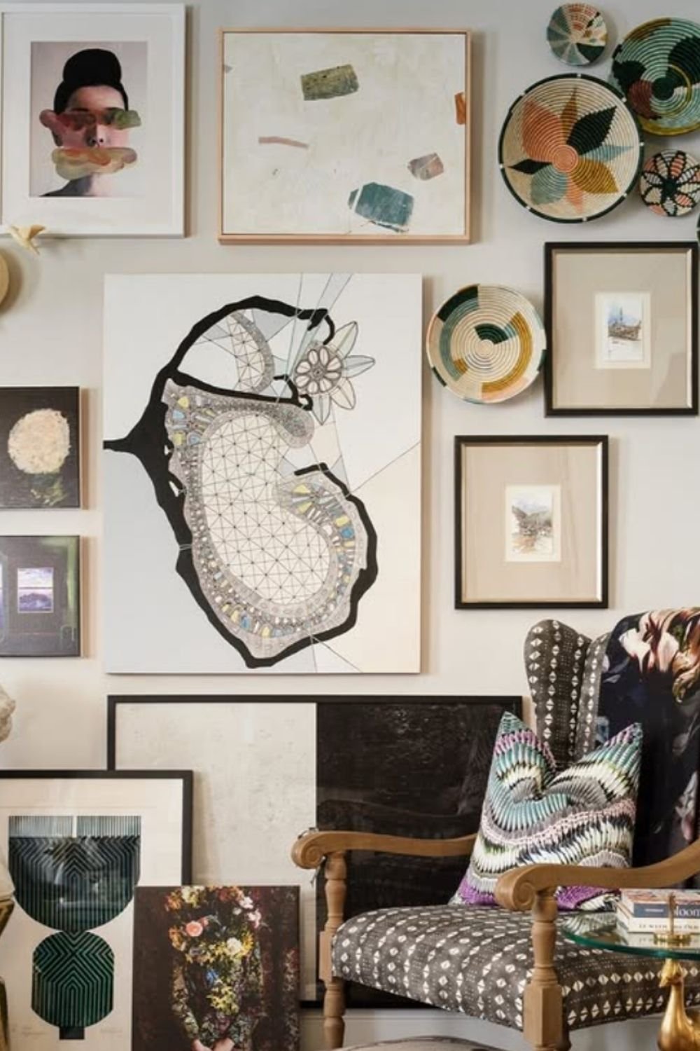 Eclectic gallery wall with muted colors and layered abstract artwork in a sophisticated setting.
