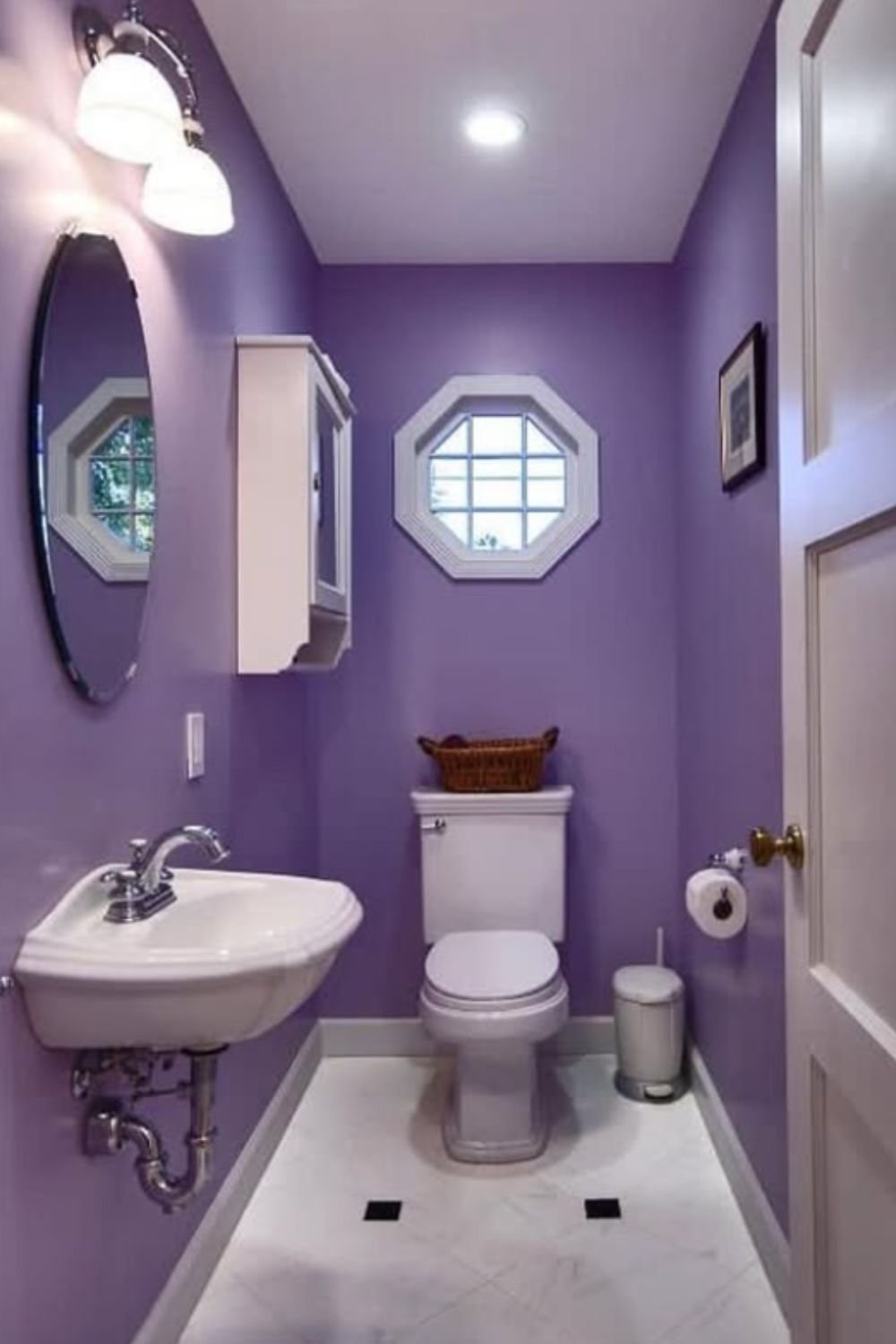 Fresh bathroom with purple-painted walls, white fixtures, and natural light from an octagon window.