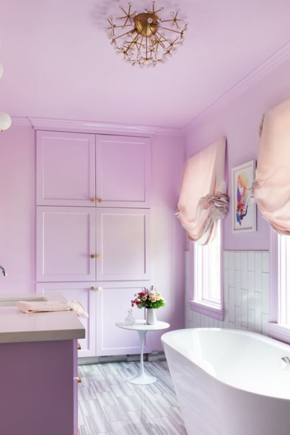 Airy lavender bathroom with marble floors, freestanding tub, and blush-pink accents for a romantic touch.