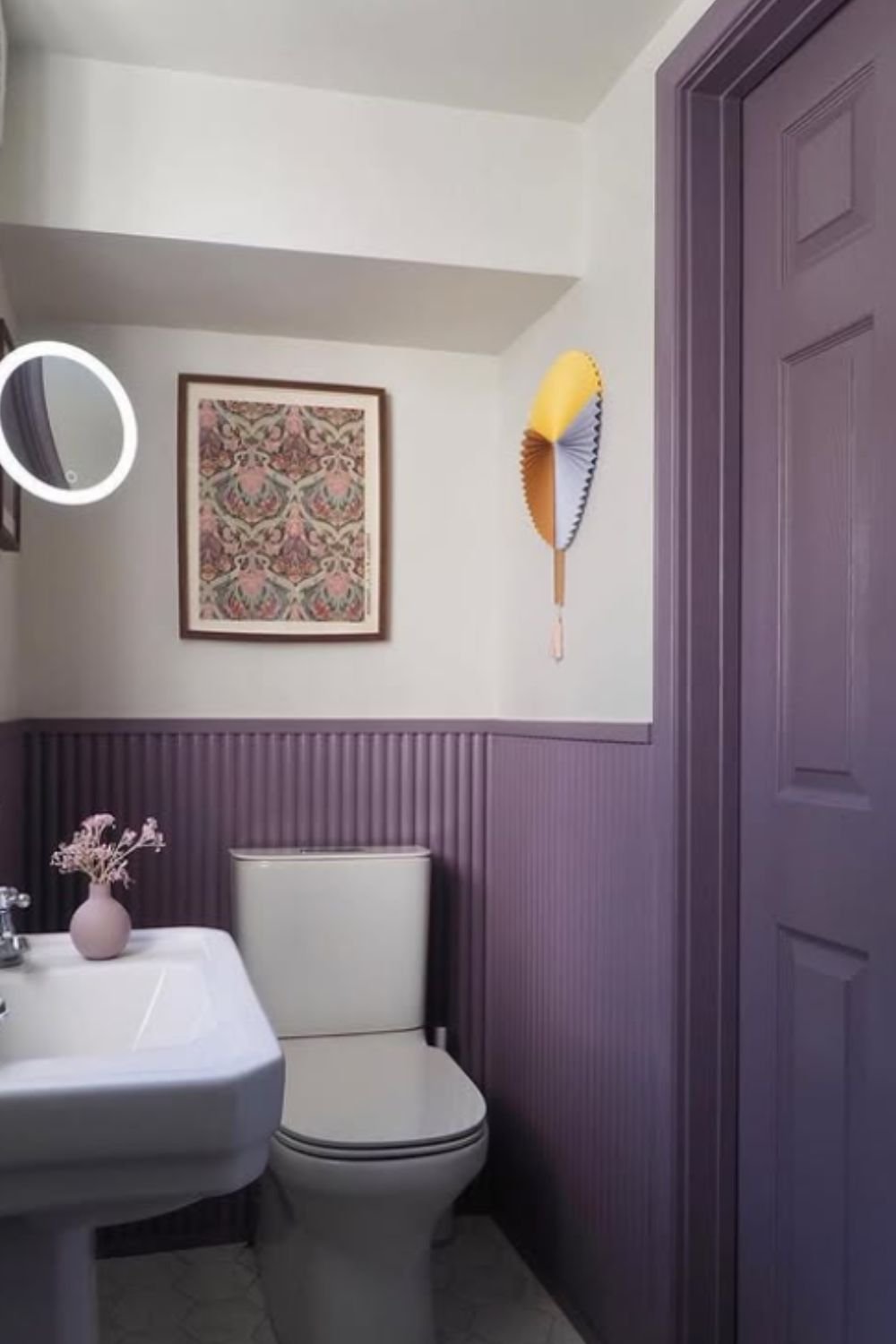 Refined bathroom with plum half-paneling, cream walls, and minimalist decor for a simple, elegant look.