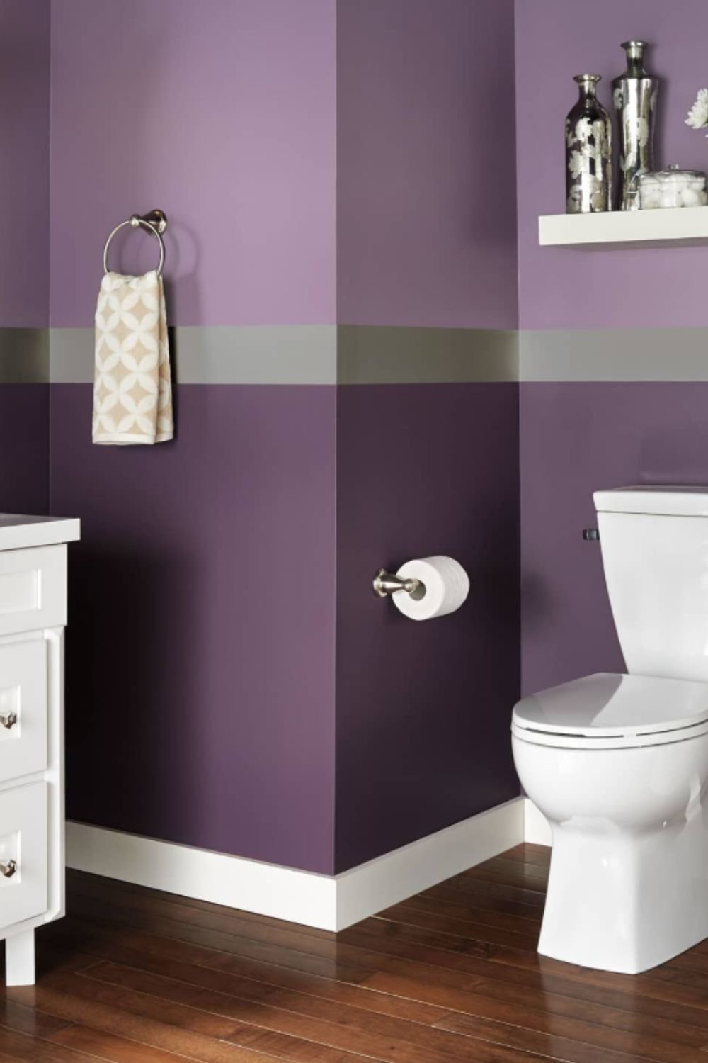 Bold purple accent wall with sleek gray stripe and modern fixtures, showing contemporary purple bathroom ideas.