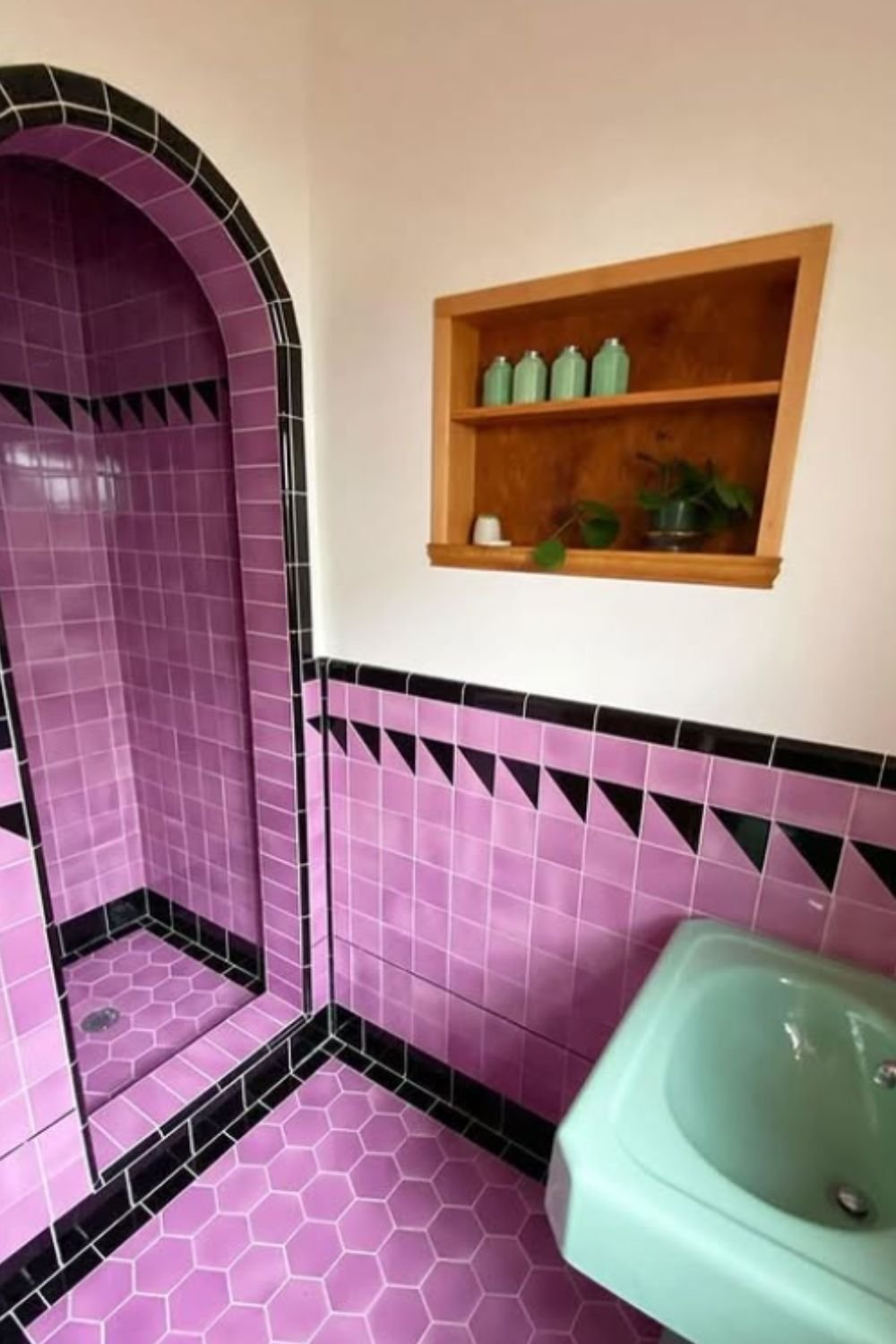 Playful lavender bathroom with glossy hexagonal tiles and black trim, highlighting retro-inspired purple bathroom ideas.