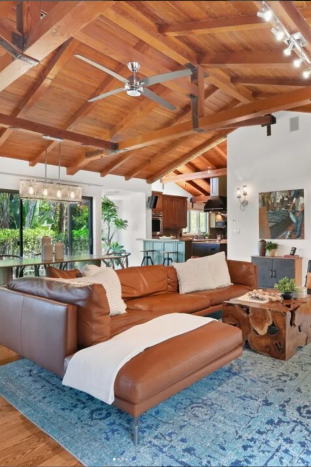 Bright living room with wooden ceiling beams and leather seating