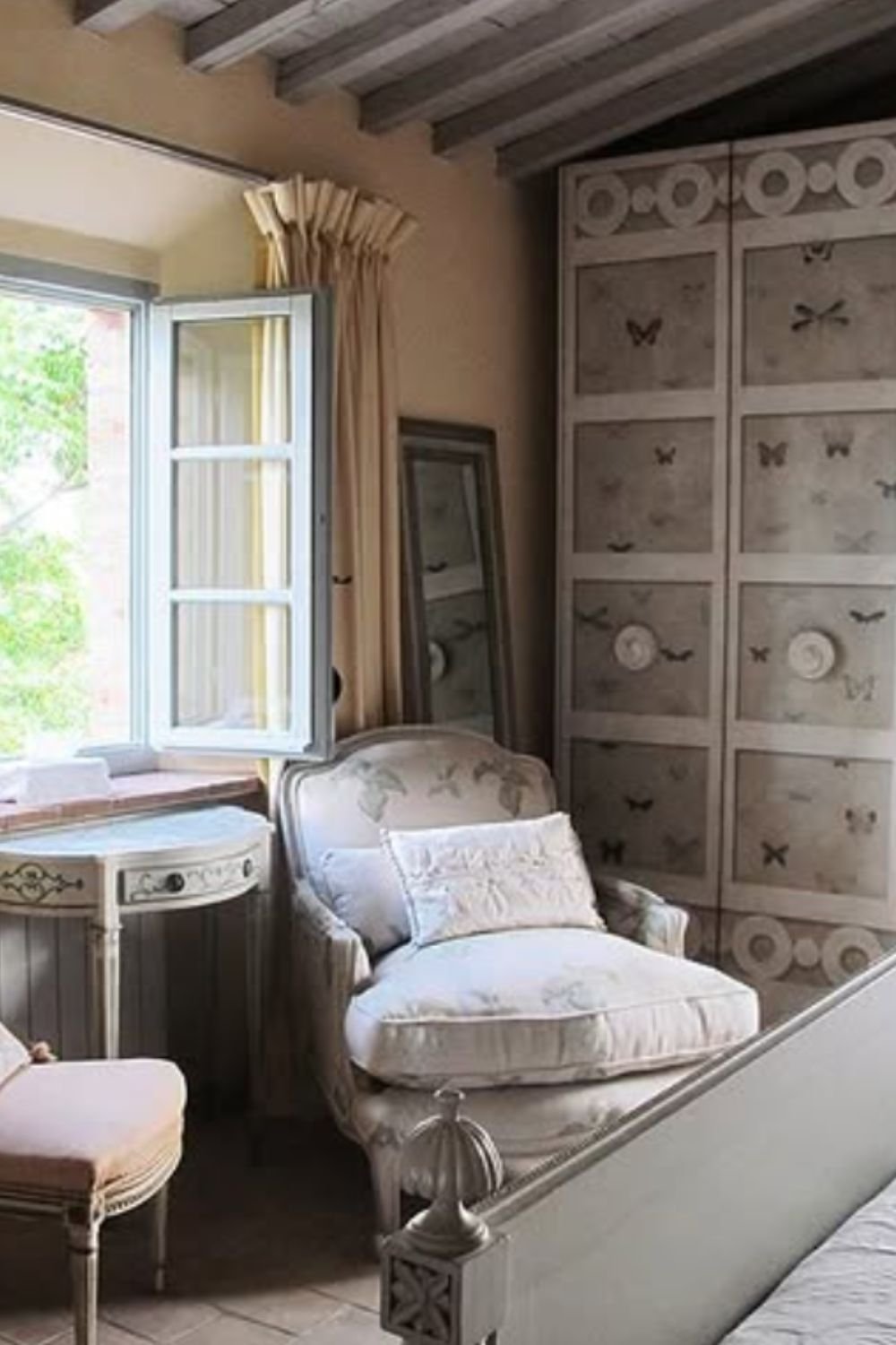 Rustic bedroom with antique wooden wardrobe and vintage armchair