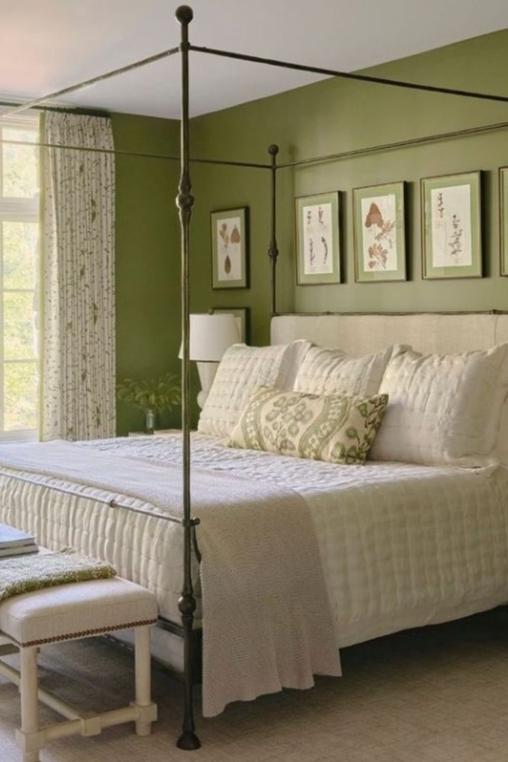 Bedroom with four-poster bed, green walls, and natural light
