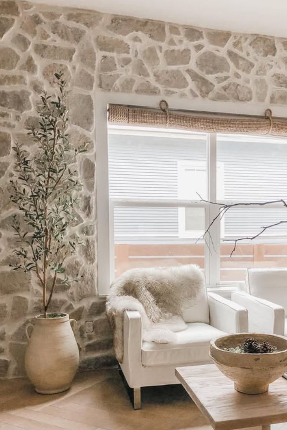 Cozy stone wall interior with armchair, wood accents, and soft textures – tuscan style home interior design
