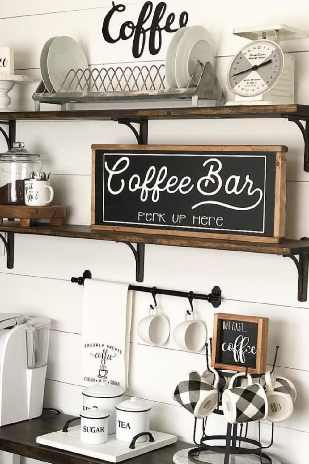 White coffee bar with handwritten calligraphy sign, mugs, and jars.